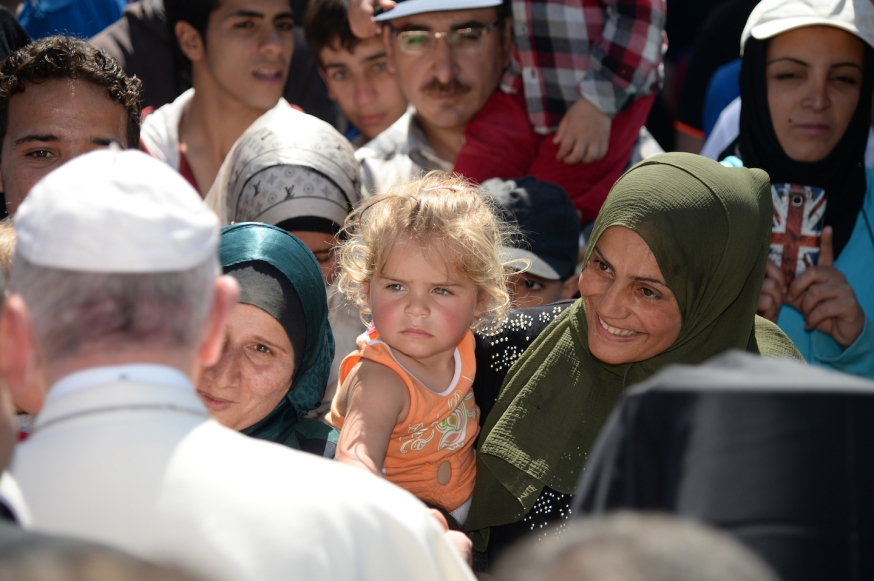 Pope Francis greets migrants and refugees at the Moria refugee camp on April 16, 2016 near the port of Mytilene, on the Greek island of Lesbos. Pope Francis received an emotional welcome today on the Greek island of Lesbos during a visit aimed at showing solidarity with migrants fleeing war and poverty. Pope Francis, Orthodox Patriarch Bartholomew and Archbishop Jerome visit Lesbos today to turn the spotlight on Europe's controversial deal with Turkey to end an unprecedented refugee crisis. AFP PHOTO POOL / FILIPPO MONTEFORTE / AFP PHOTO / POOL / FILIPPO MONTEFORTE
